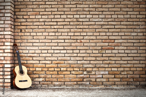 chitarra classica e muro di mattoni