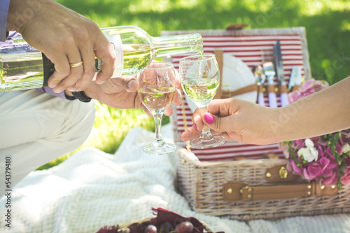 Two glasses of white wine with picnic basket. 