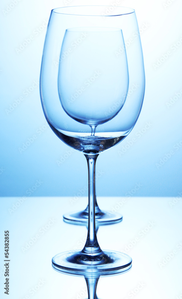 Empty wine glasses arranged on blue background Empty wine glasses arranged on blue background