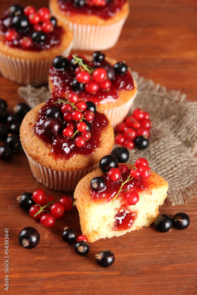 Tasty muffins with berries on wooden table Tasty muffins with berries on wooden table