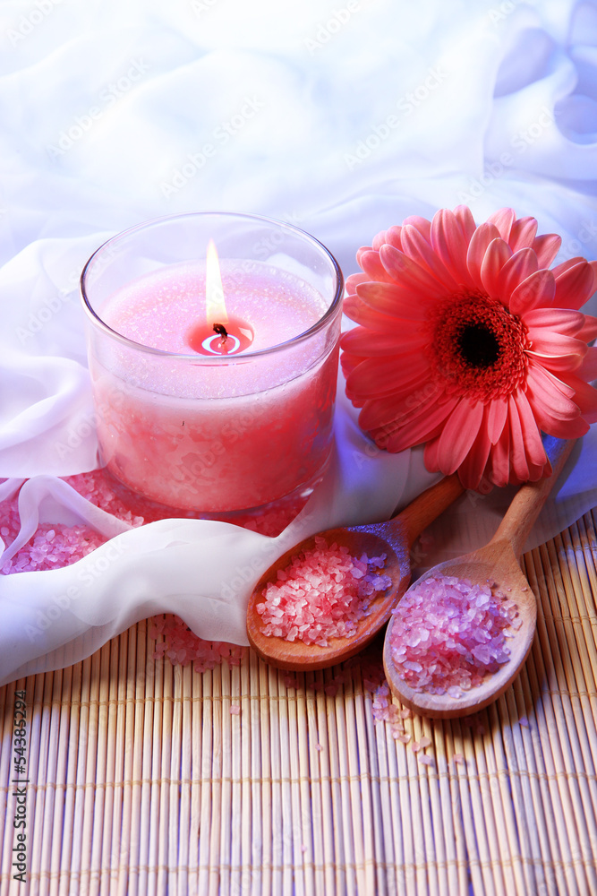 Beautiful candle with flower on white cloth, close up Beautiful candle with flower on white cloth, close up