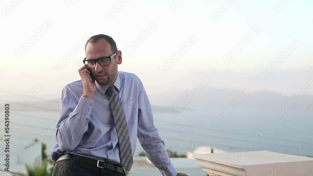 Young handsome businessman talking on mobile phone on terrace Young handsome businessman talking on mobile phone on terrace