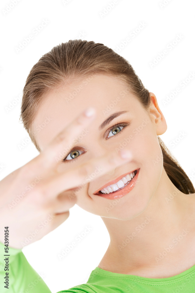 Happy young teenager girl showing victory sign Happy young teenager girl showing victory sign