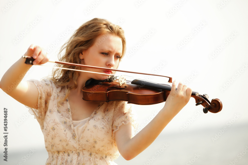 Portrait blonde girl with a violin outdoor