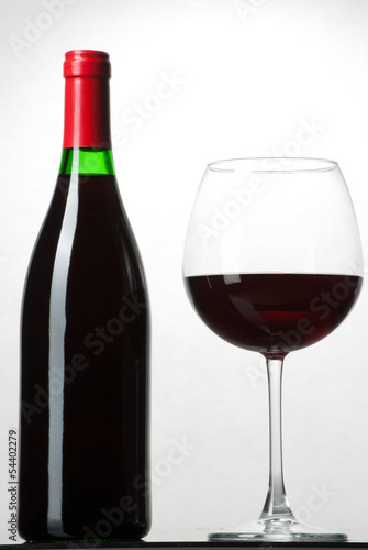 Wine bottle and a glass filled with wine isolated on white