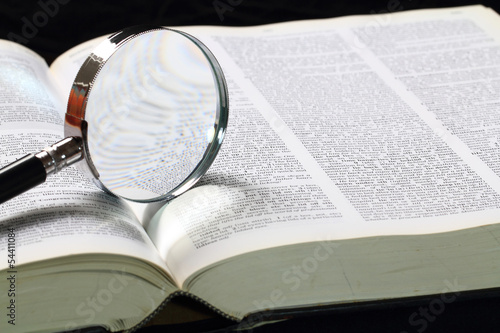Dictionary and magnifying glass photo