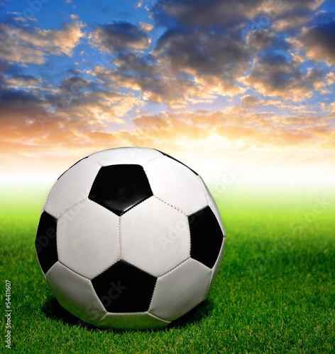 soccer ball on grass in the sunset