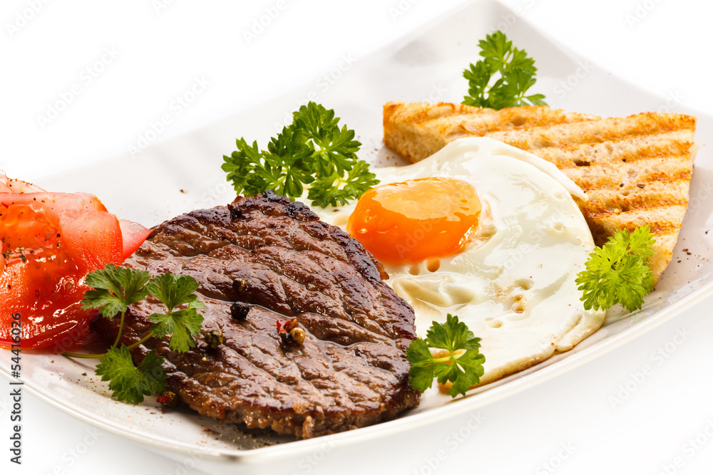 Grilled steak, toast, fried egg and vegetables Grilled steak, toast, fried egg and vegetables