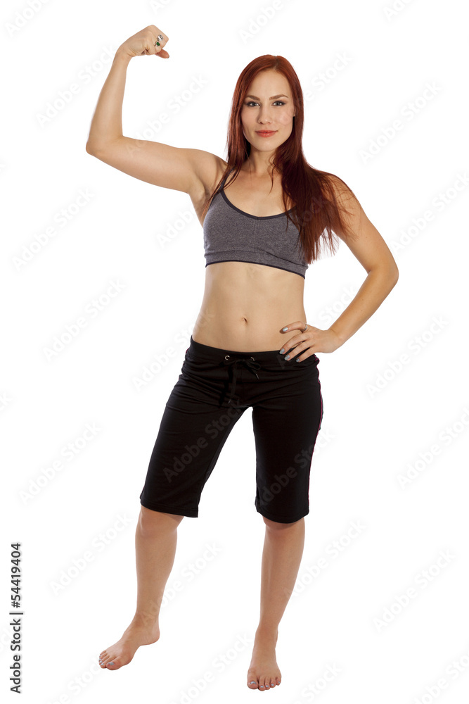 Young woman flexes her muscles in fitness clothing. Young woman flexes her muscles in fitness clothing.