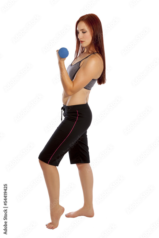 Young woman works her biceps with hand weights. Young woman works her biceps with hand weights.