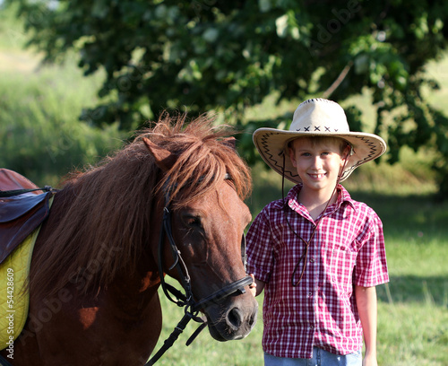 boy with cowboy hat and pony horse
