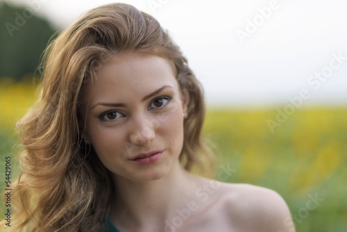 young beautiful woman on blooming sunflower field in summer