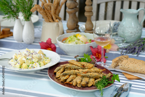 Fried sardines with potato salad, bread , white wine