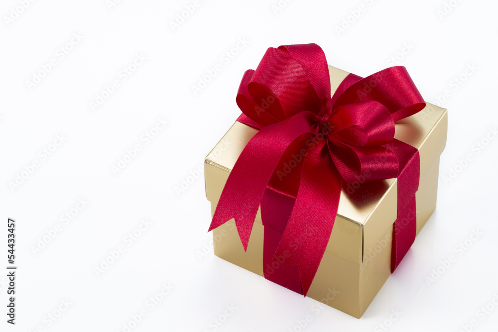 Beautiful gold present box with red bow and ribbons Beautiful gold present box with red bow and ribbons