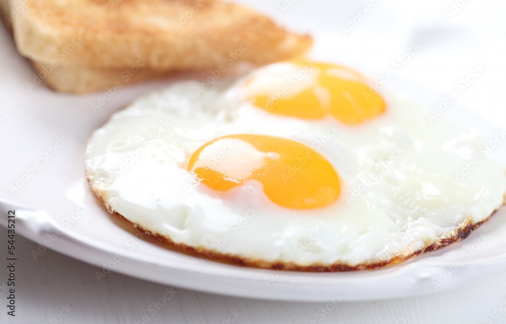Detail of plate with fried eggs and toasts Detail of plate with fried eggs and toasts