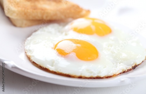 Detail of plate with fried eggs and toasts