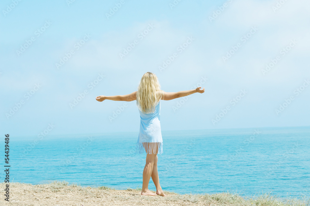 girl standing on the beach arms outstretched girl standing on the beach arms outstretched