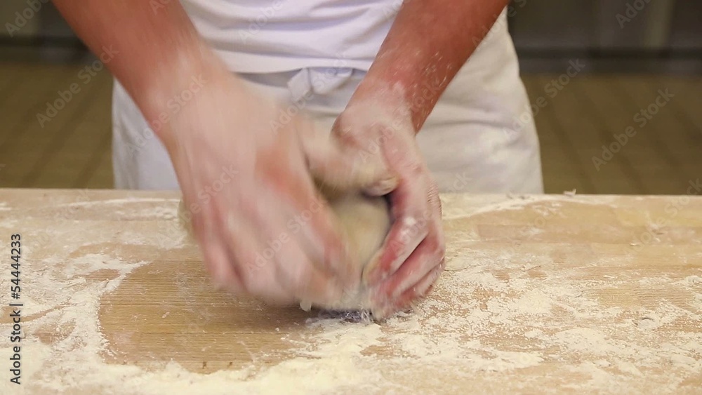 Baker kneading bread dough in bakery or bakerhouse Baker kneading bread dough in bakery or bakerhouse