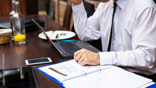 Hard working businessman in restaurant. Close-up.