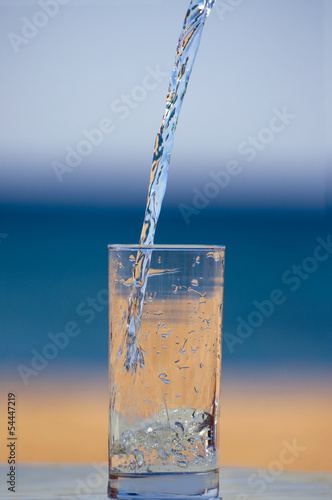 Чистая питьевая вода льется в стакан