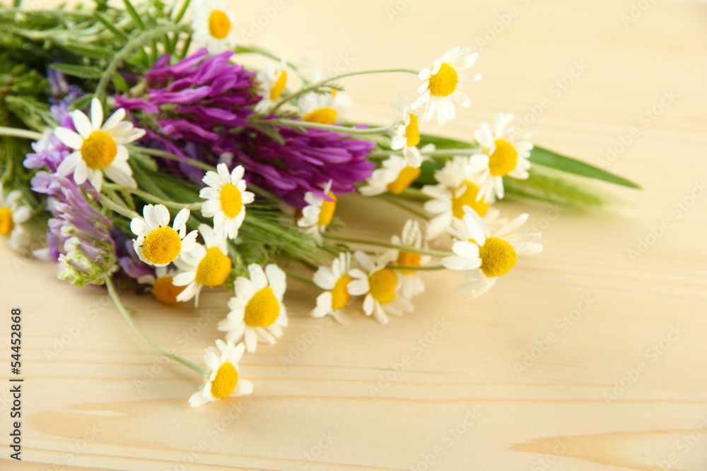 Obraz premium Wild flowers and green spikelets, on wooden background