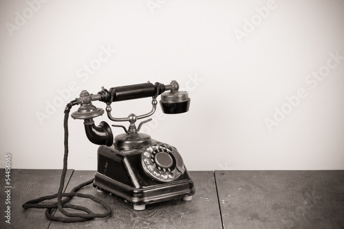 Vintage old telephone on wood table black and white photo