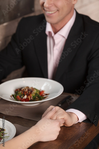 Loving couple at the restaurant. Top view of cheerful businessma