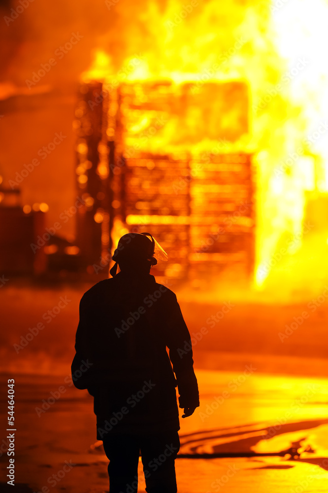 Fototapeta premium Feuerwehrmann vor Flammenhölle