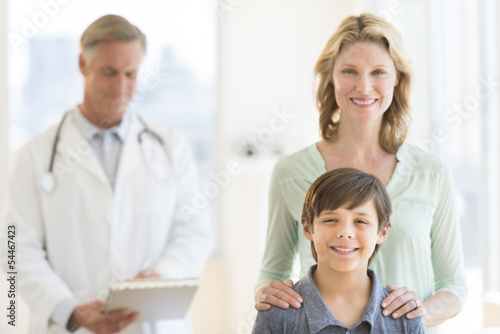 Mother And Son With Doctor Examining Report In Background