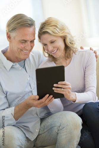 Loving Couple Using Digital Tablet At Home