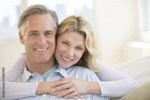 Loving Woman Embracing Man From Behind At Home