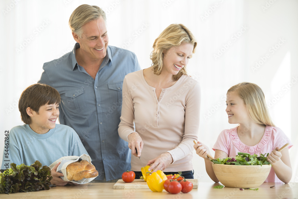 Parents And Children Cooking Food Together At Counter