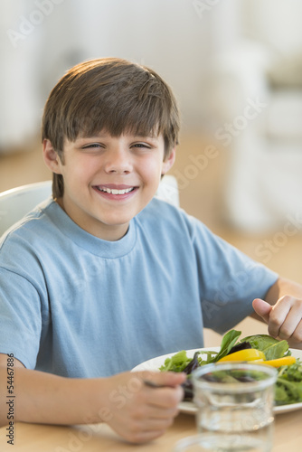 Boy Having Fresh Salad At Dining Table