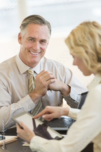 Confident Businessman With Coworker Using Digital Tablet In Offi