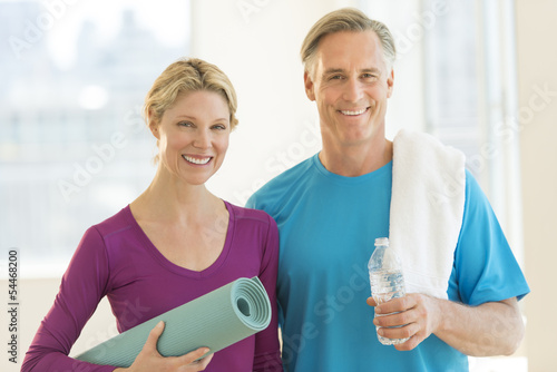 Couple With Exercise Mat; Water Bottle And Towel In Club