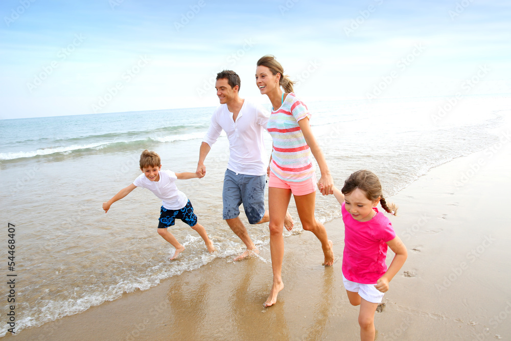 Happy family running on the beach Happy family running on the beach