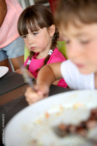 Portrait of little girl sitting at table for lunch