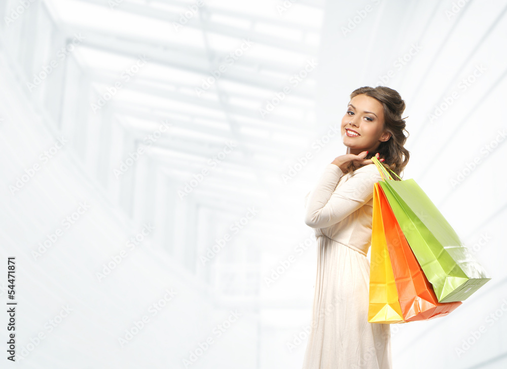 Beautiful woman in a white dress with bright shopping bags Beautiful woman in a white dress with bright shopping bags