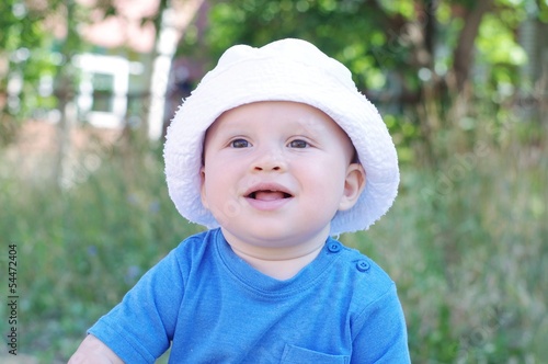 portrait of smiling baby in white hat