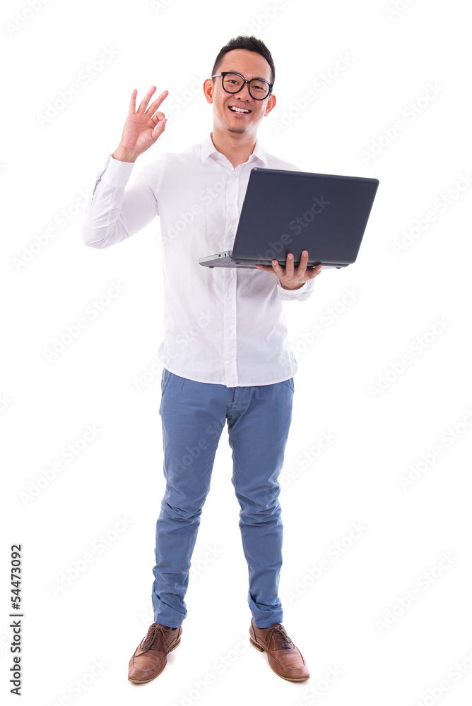 Asian man using laptop showing ok sign Asian man using laptop showing ok sign