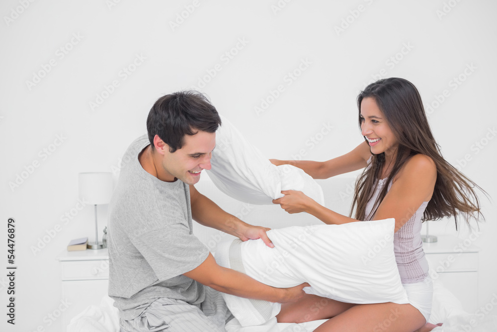 Fototapeta premium Couple having fun with a pillow fight