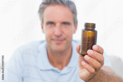 Man showing bottle of pills to camera