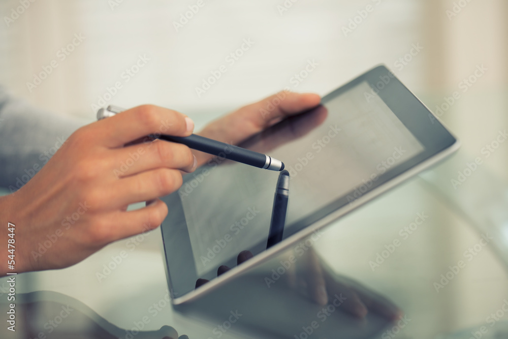 Close-up of woman working with stylus and digital tablet pc - obrazy, fototapety, plakaty 