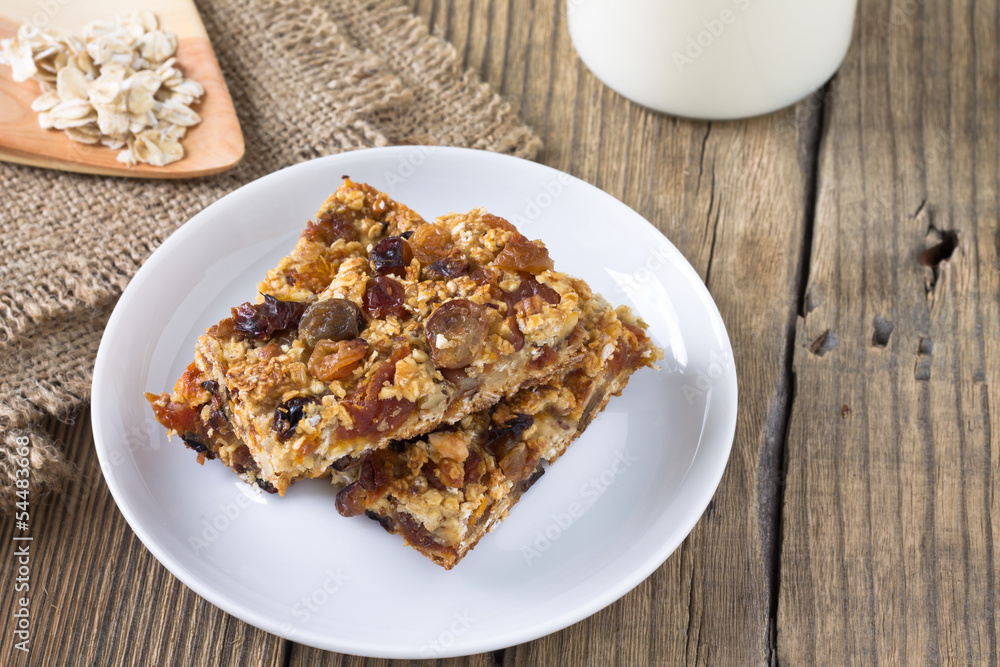 Granola bars with nuts and dried fruits, glass of milk Granola bars with nuts and dried fruits, glass of milk
