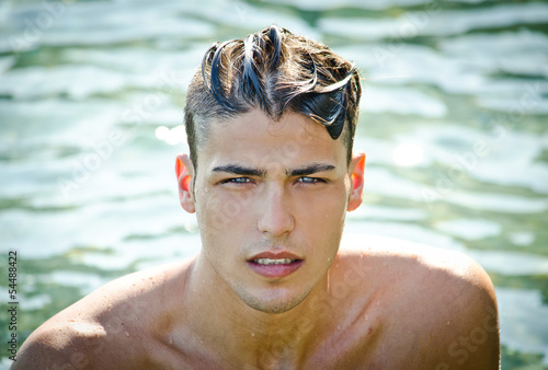 Foto Handsome young man getting out of water with wet hair