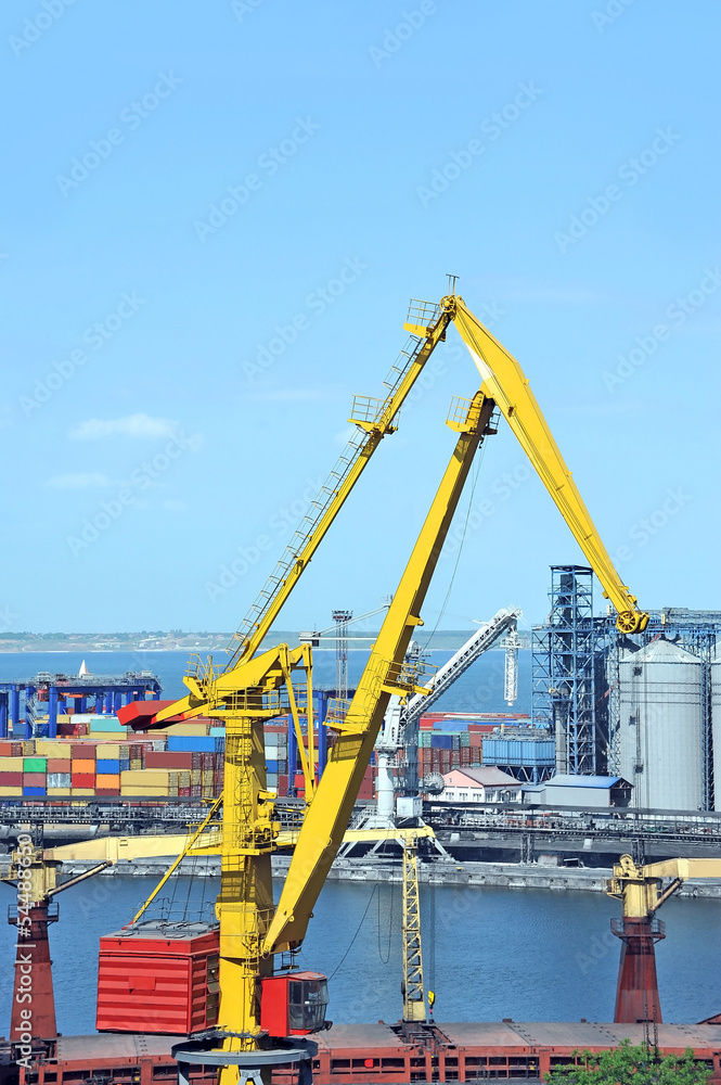 Port cargo crane and container over blue sky background