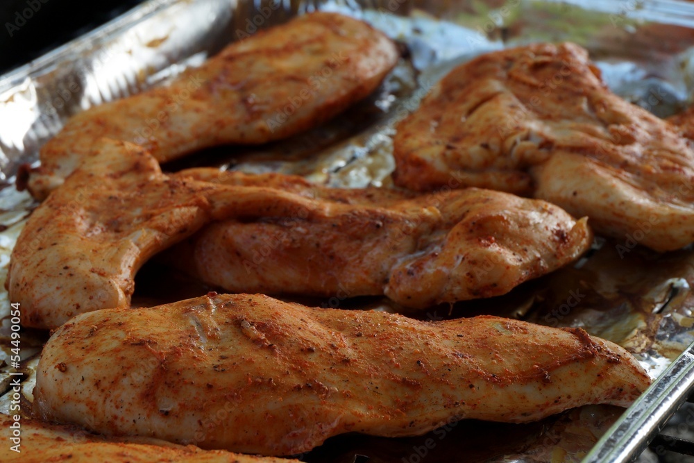 Grilled spiced chicken breast on alluminium tray