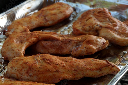 Grilled spiced chicken breast on alluminium tray