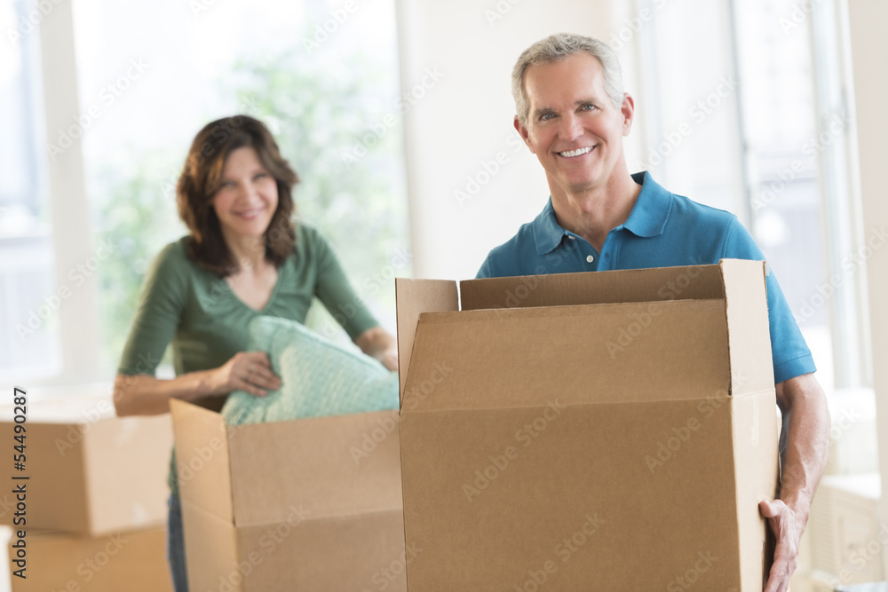 Couple With Cardboard Boxes In New House Couple With Cardboard Boxes In New House