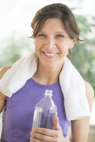 Happy Woman With Water Bottle And Towel Around Neck